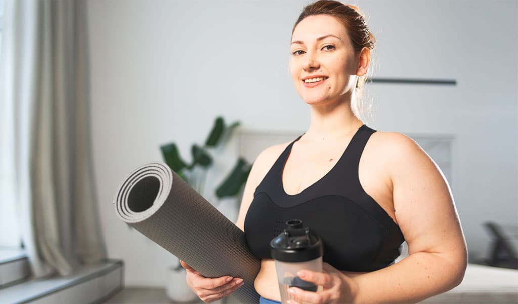 Active woman with yoga mat representing the advanced combination weight-loss protocol at Body Slim Atlanta